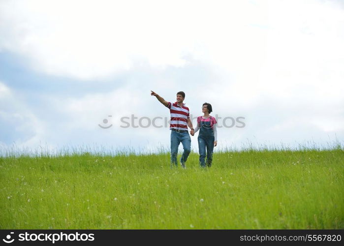 Portrait of romantic young couple in love smiling together outdoor in nature with blue sky in background