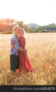 Portrait of romantic young couple standing in wheat field, Majorca, Spain