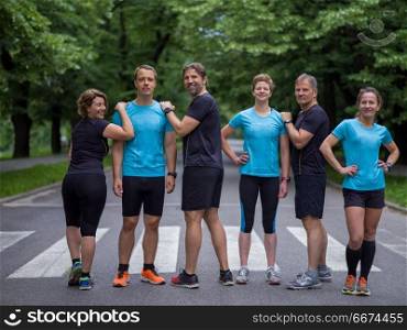 portrait of runners team on morning training. portrait of a group healthy people jogging in city park, runners team on morning training