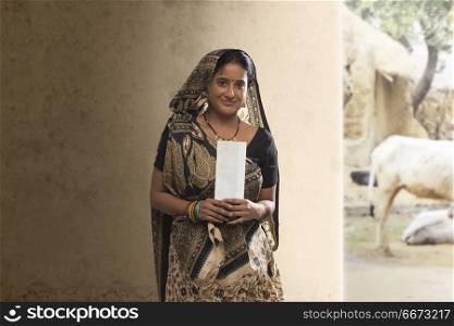 Portrait of rural woman holding bank cheque