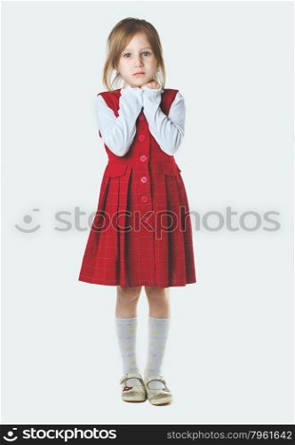 Portrait of sad blond little girl on light background