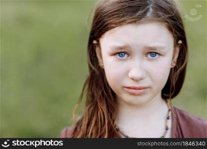 Portrait of sad crying emotional cute little girl looking at camera with face of deep sadness and sorrow outdoors. Sad child with blue eyes, copy space.. Portrait of sad crying emotional cute little girl looking at camera with face of deep sadness and sorrow outdoors. Sad child with blue eyes, copy space