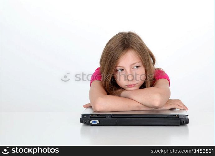 Portrait of sad little girl with laptop computer