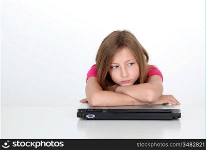 Portrait of sad little girl with laptop computer