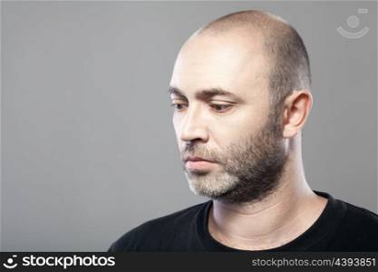 portrait of sad mature caucasian man isolated on gray background with copyspace