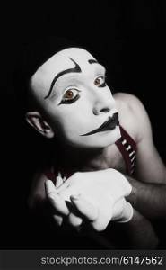 Portrait of sad mime on black background