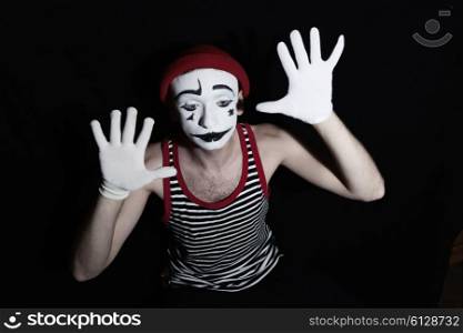 Portrait of sad mime wearing hat on black background