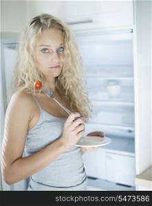 Portrait of sad woman having cherry tomato in kitchen