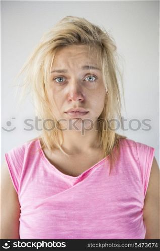 Portrait of sad woman suffering from cold against gray background
