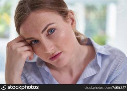 Portrait Of Sad Young Woman Suffering From Depression With Head In Hands                              