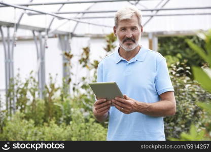 Portrait Of Sales Assistant In Garden Center With Digital Tablet