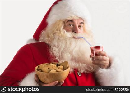 Portrait of Santa Claus Drinking milk from glass and holding bowl of cookies. Greeting card background