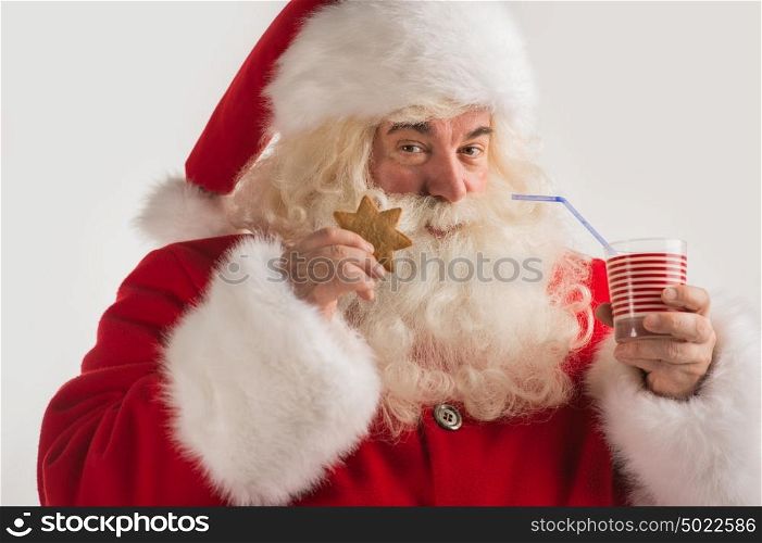 Portrait of Santa Claus Drinking milk from glass and holding cookie. Greeting card background