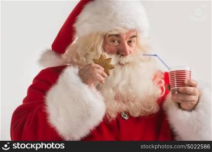 Portrait of Santa Claus Drinking milk from glass and holding cookie. Greeting card background