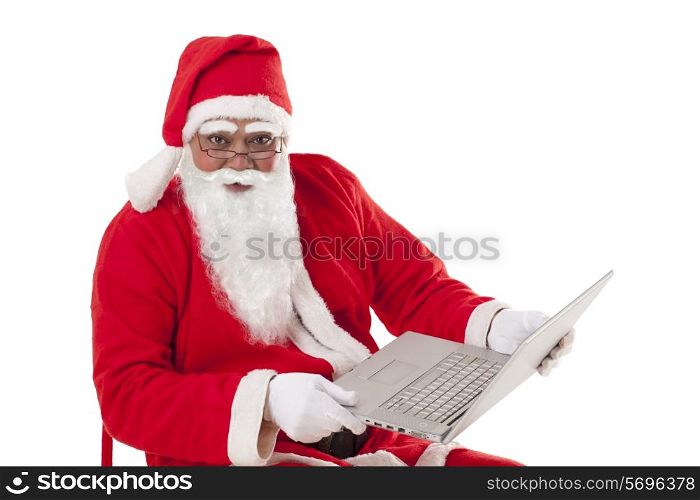 Portrait of Santa Claus holding laptop over white background