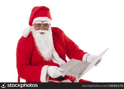 Portrait of Santa Claus holding laptop over white background