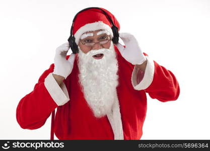 Portrait of Santa Claus listening to music over white background