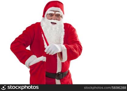 Portrait of Santa Claus removing gift from bag over white background