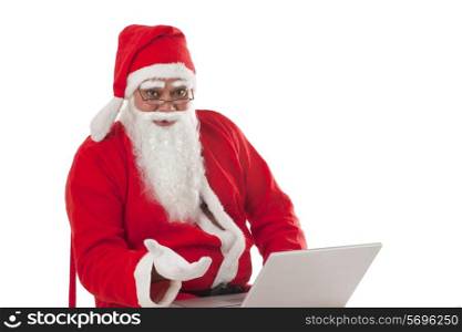 Portrait of Santa Claus with laptop against white background