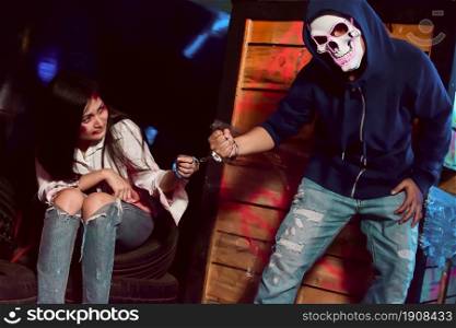 Portrait of scary murderer arresting and killing female victim. Halloween, Horror and Social Problem Concept.
