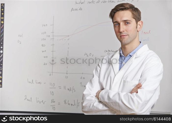 Portrait Of Science Teacher Standing In Front Of Whitebaord