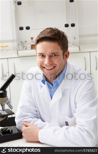 Portrait Of Scientist With Microscope In Laboratory