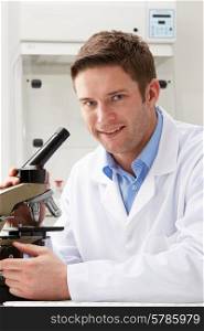 Portrait Of Scientist With Microscope In Laboratory