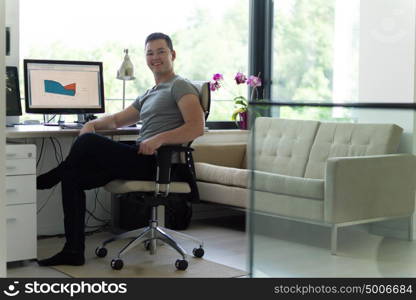 portrait of security system operator looking at CCTV footage at desk in office