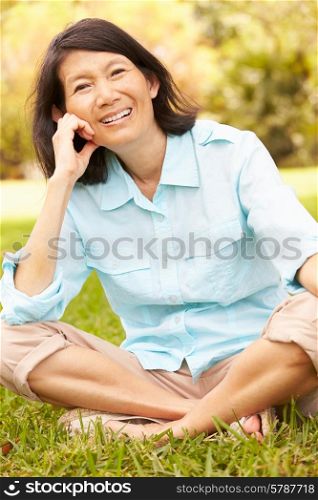Portrait Of Senior Asian Woman Sitting In Park