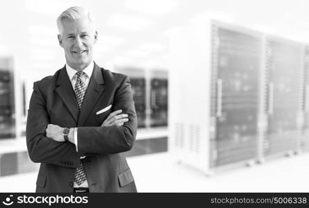 Portrait of senior businessman in big rack server room