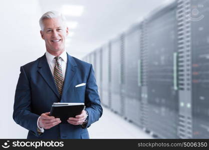 Portrait of senior businessman in big rack server room