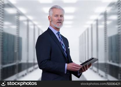 Portrait of senior businessman in big rack server room
