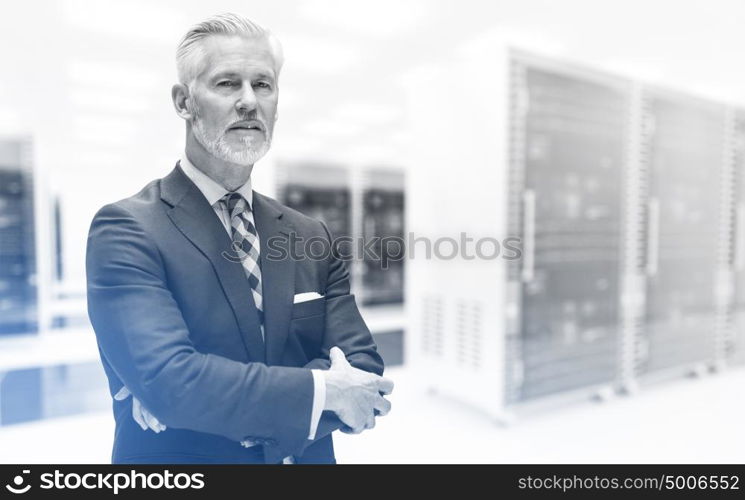 Portrait of senior businessman in big rack server room