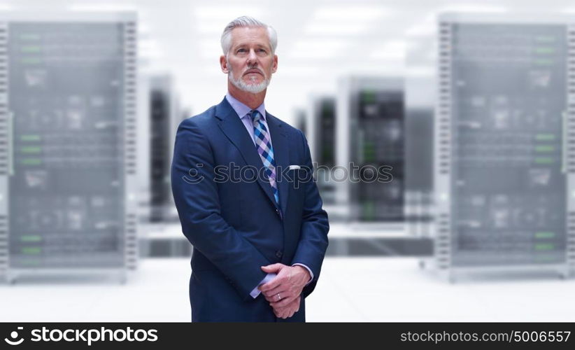 Portrait of senior businessman in big rack server room