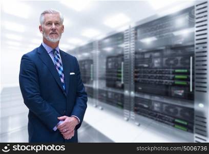 Portrait of senior businessman in big rack server room