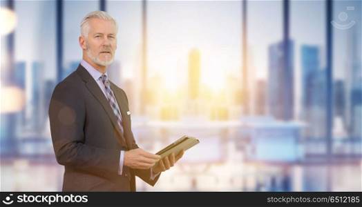 Portrait of senior businessman in front of his modern office with sun flares. Senior businessman in his office