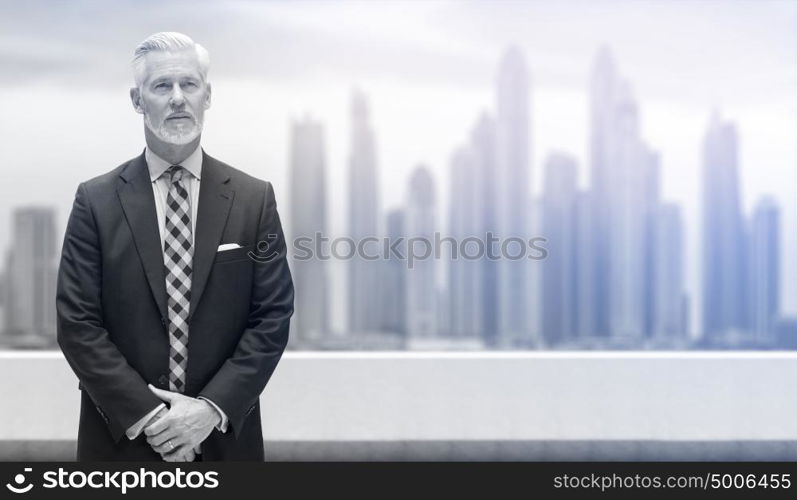 Portrait of senior businessman in front of the big city