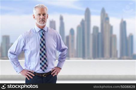 Portrait of senior businessman in front of the big city