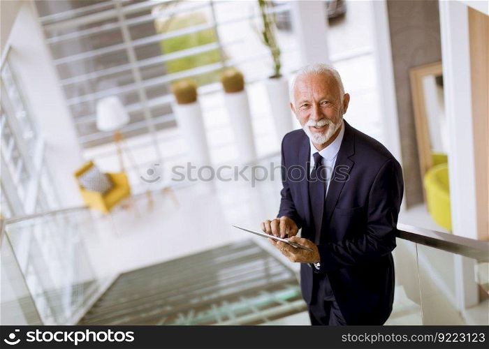 Portrait of senior businessman using digital tablet in the office