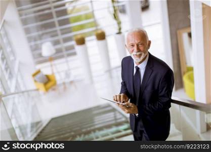 Portrait of senior businessman using digital tablet in the office