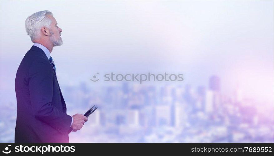 Portrait of senior businessman using tablet in front of big modern city