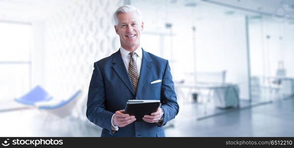 Portrait of senior businessman using tablet in front of his modern office. Senior businessman in his office