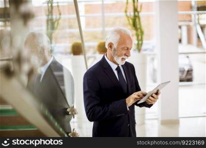 Portrait of senior businessman with digital  tablet in modern office office