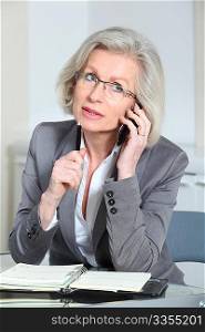Portrait of senior businesswoman talking on the phone in office