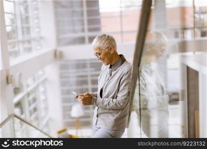 Portrait of senior businesswoman using mobile phone in modern ofice