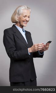 Portrait of senior businesswoman using smartphone in studio