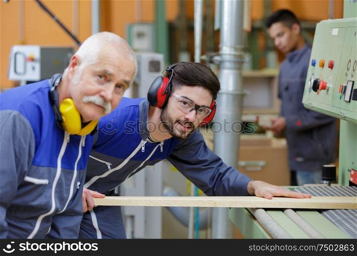 portrait of senior carpenter and his son in their workshop