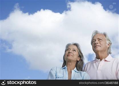 Portrait of senior couple against sky, looking up