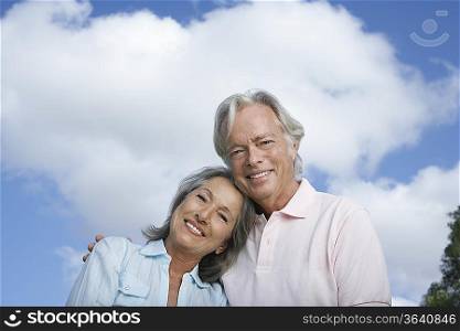 Portrait of senior couple against sky, smiling