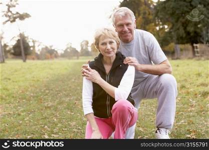 Portrait Of Senior Couple Crouching In The Park